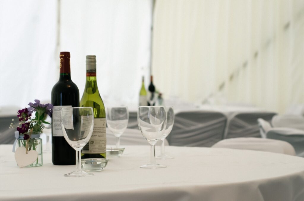 Wine bottles and glasses on tables before the wedding reception.
